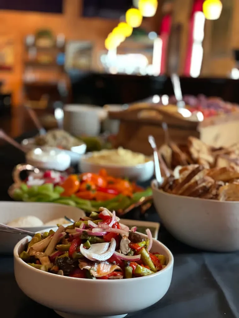 Colorful vegetable and mushroom salad in a white bowl on a buffet.