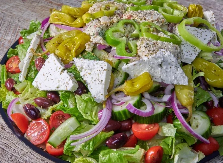 Vibrant large Greek salad with creamy protein and feta.