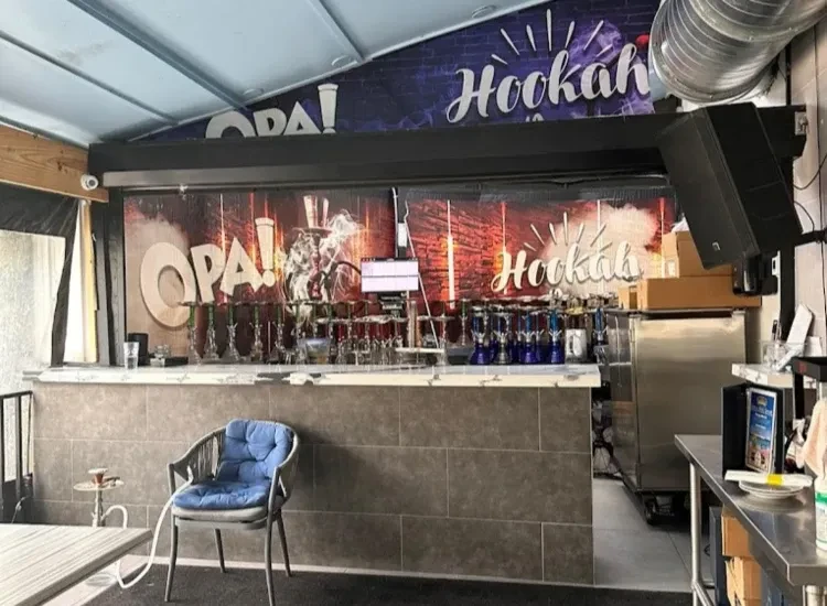 Hookah bar interior: counter with pipes, 'Opa! Hookah' wall.