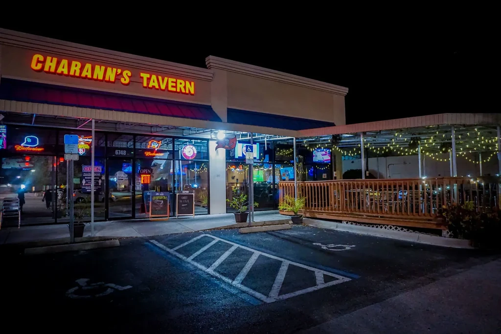 Illuminated Charann's Tavern exterior at night with string-lit outdoor patio.