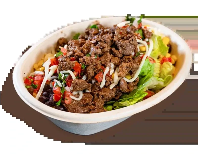 Vibrant top-down burrito bowl with meat, lettuce, beans, corn, and cheese.