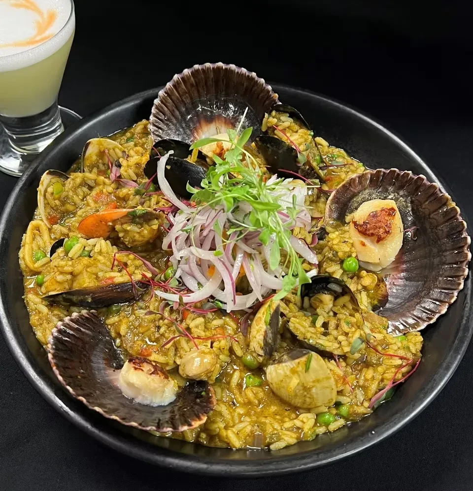 Vibrant seafood rice dish with seared scallops, mussels, shrimp, and peas.