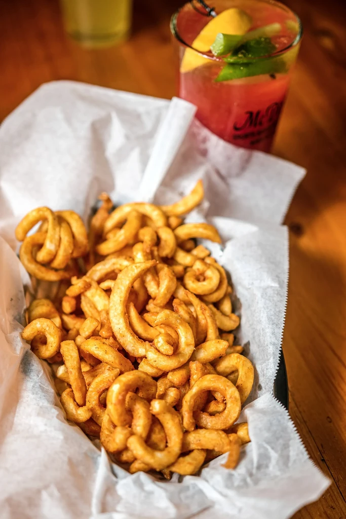 Basket of crispy, seasoned curly fries and a McDonald's drink.
