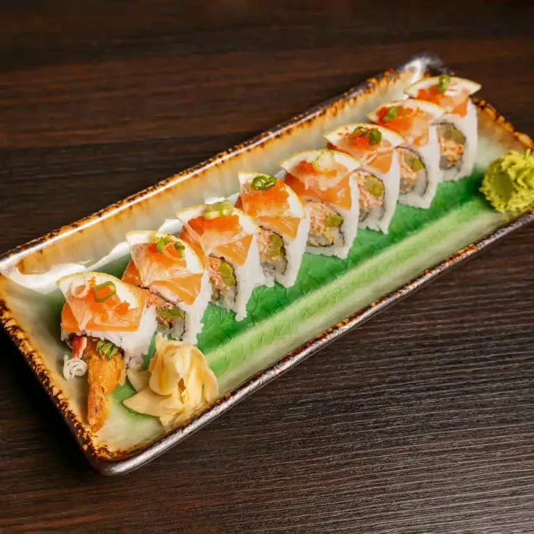 Ten salmon and tempura sushi rolls with ginger and wasabi.