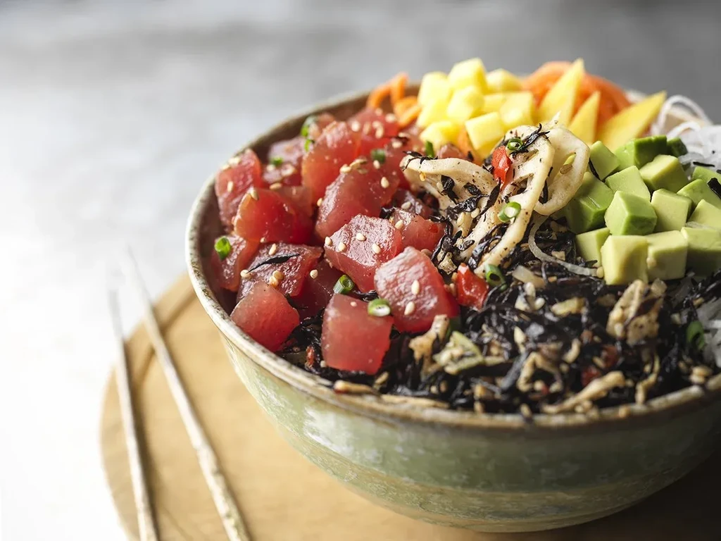 Fresh tuna poke bowl with avocado, mango, lotus root slices.
