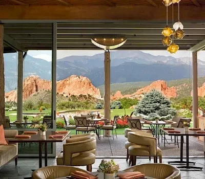 Elegant restaurant interior and patio with panoramic red rock mountain views.
