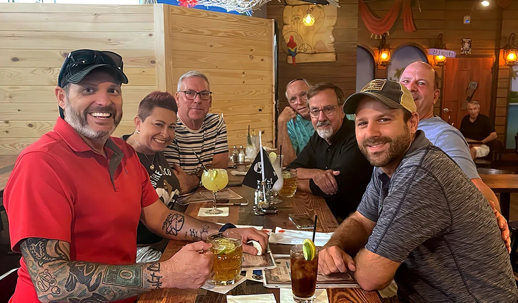 Smiling group of adults in a pirate-themed restaurant with drinks.