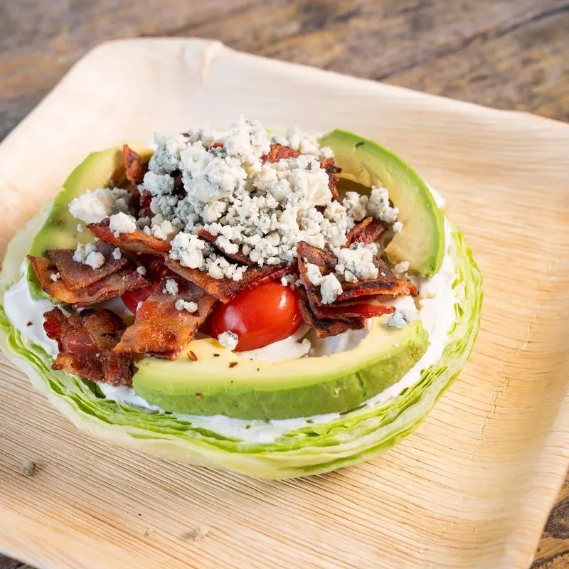 Deconstructed wedge salad: lettuce, creamy dressing, avocado, tomatoes, bacon, blue cheese.