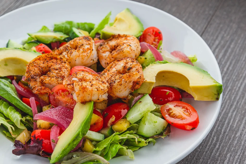Grilled shrimp salad with avocado, tomatoes, and greens.