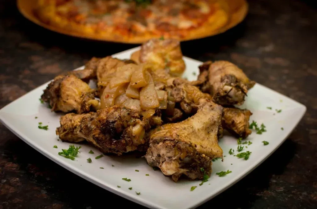 Rectangular plate with browned chicken, stewed vegetables, and parsley.