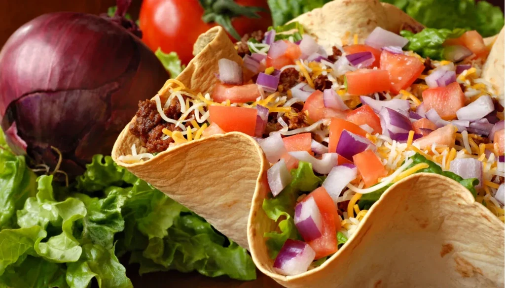 Crispy taco shell filled with ground meat, cheese, lettuce, tomatoes, onions.