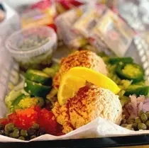 Colorful salad scoops with lemon, tomatoes, peppers, and crackers.