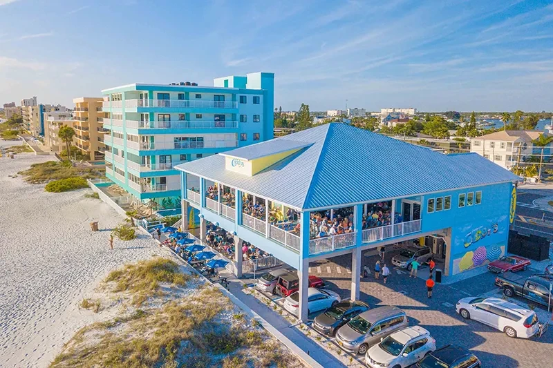 High-angle view of a blue beach restaurant packed with patrons.