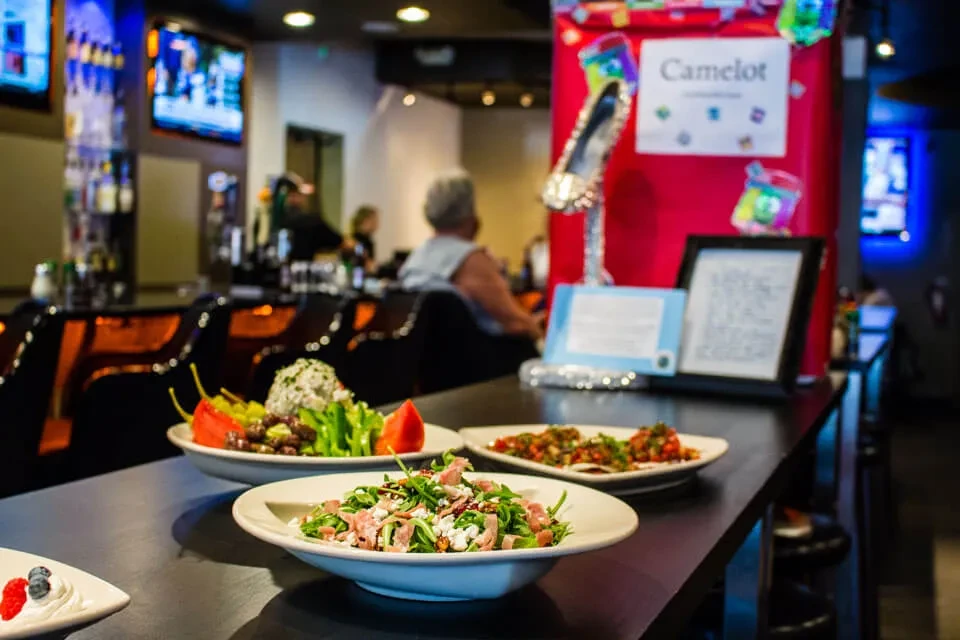 Three plates of food on a counter in a modern bar.