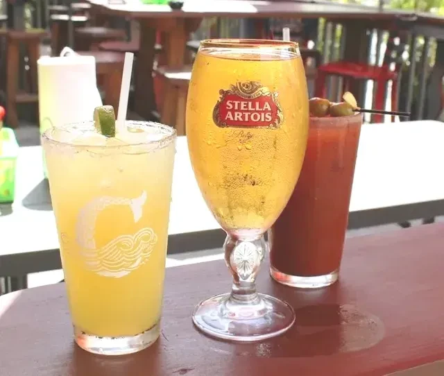 Margarita, Stella Artois beer, and Bloody Mary on an outdoor table.
