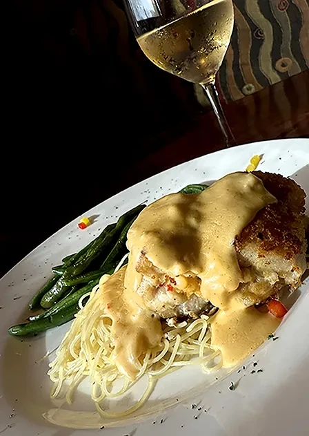 Breaded cutlet with creamy sauce, spaghetti, green beans, and white wine.