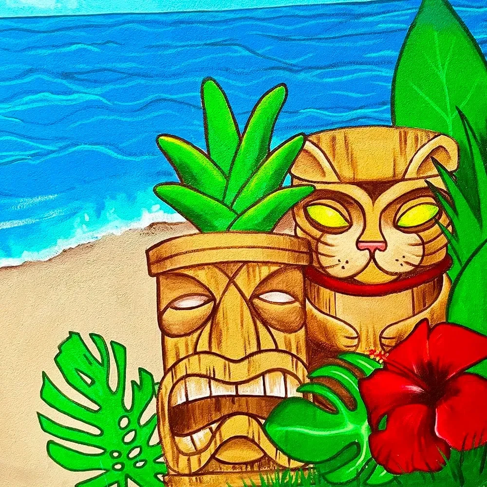 Tropical mural with cat-faced tiki, traditional tiki, leaves, beach.