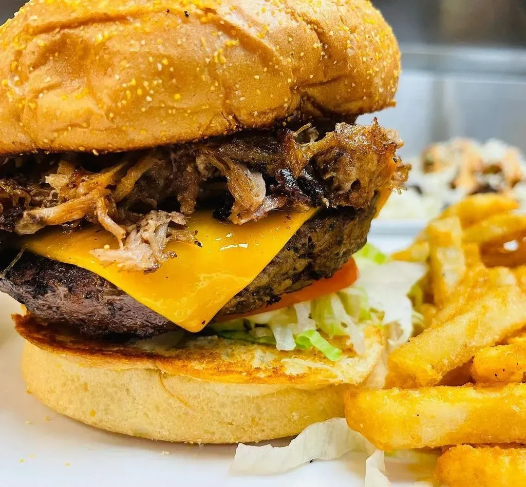 Close-up of a large burger with fries and crispy fried onions.
