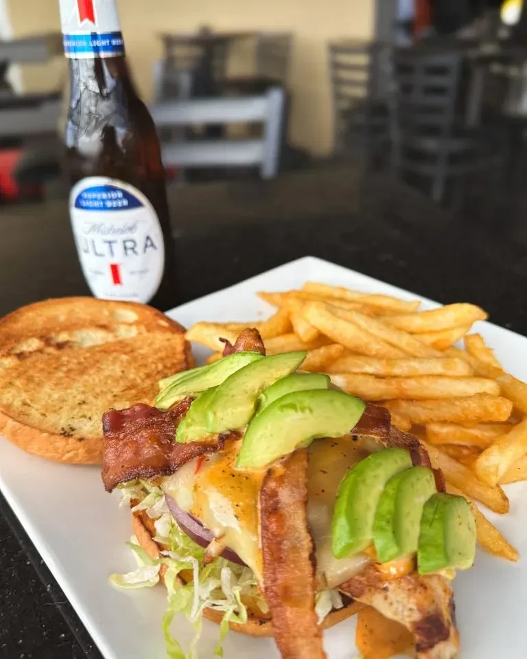 Open-faced burger with bacon, avocado, cheese, fries, and Michelob Ultra.