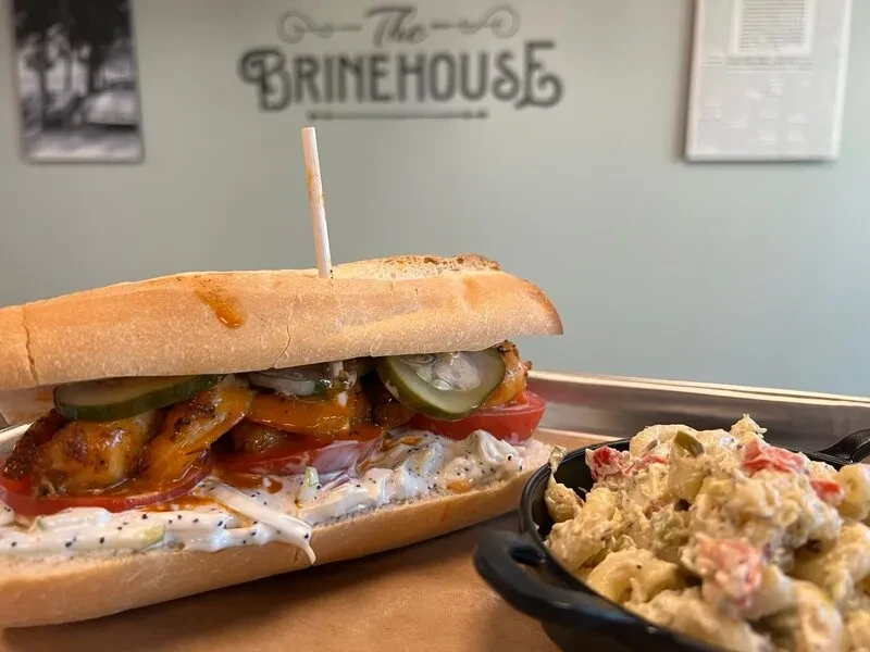 Sub sandwich, pasta salad, and 'The Brinehouse' logo on a tray.