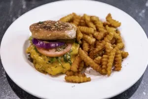 Top-down view of an open-faced cheeseburger and crinkle-cut fries.