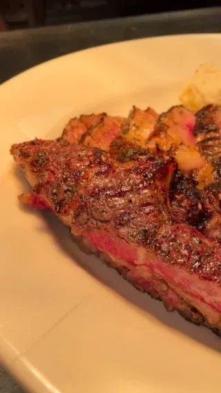 Juicy, sliced medium-rare steak with seared crust on a plate.