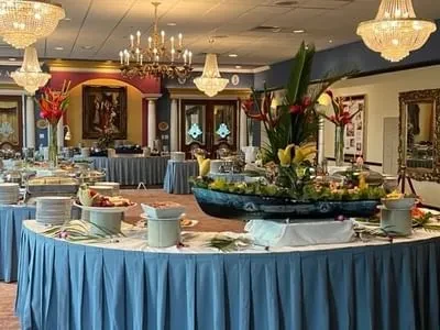 Lavish buffet with exotic flower centerpiece in an ornate grand hall.