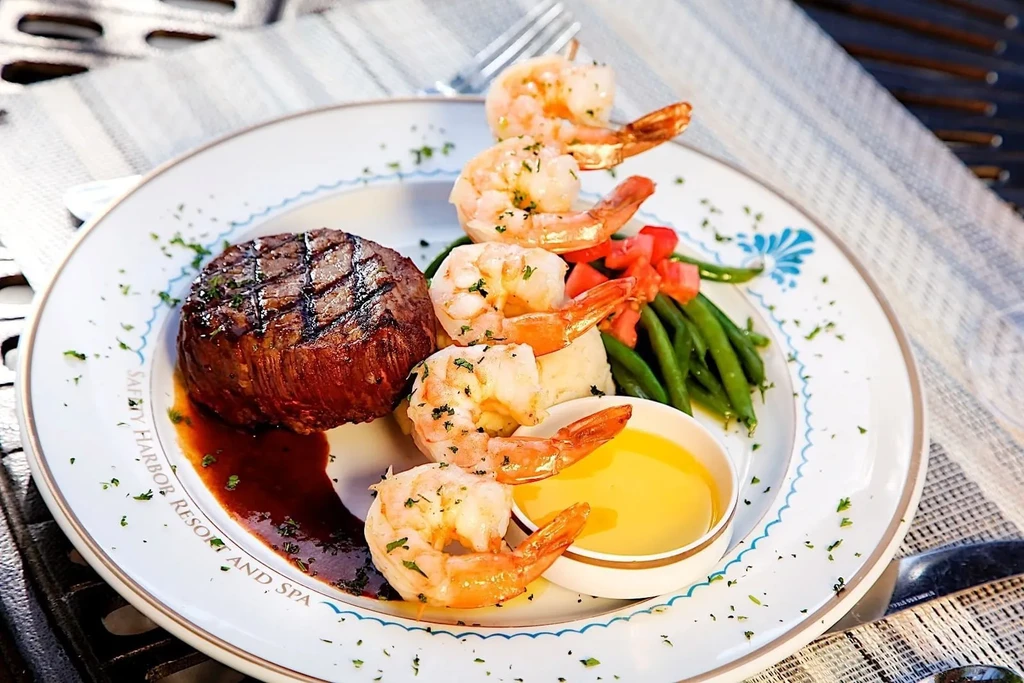 Grilled steak, five shrimp, green beans, and yellow dipping sauce.