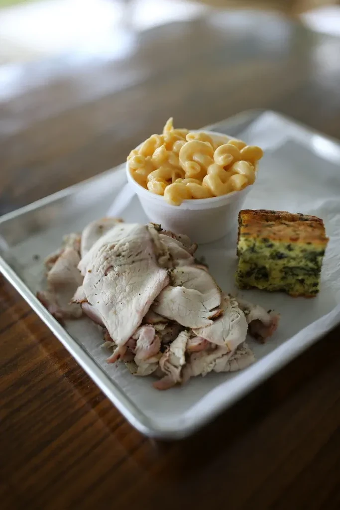 Silver tray holds sliced meat, macaroni and cheese, and spinach casserole.