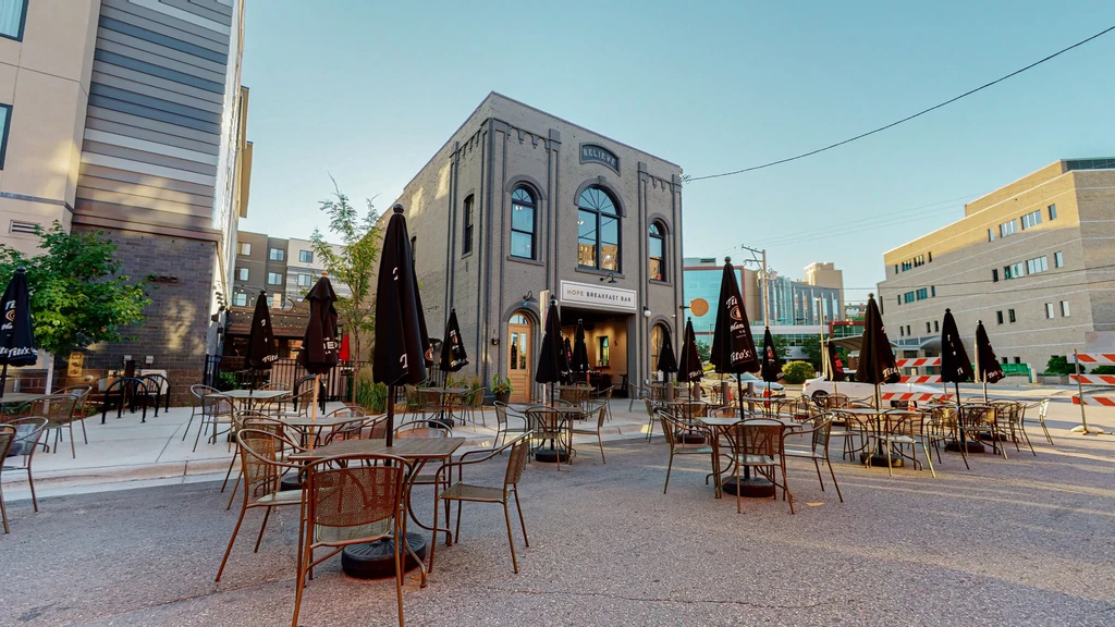 Gray brick Hope Breakfast Bar with empty extensive outdoor dining.