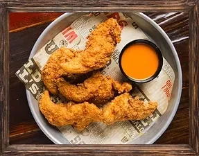 Three crispy fried chicken tenders with orange dipping sauce.