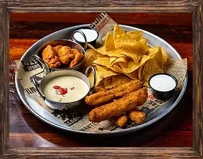Overhead platter with tortilla chips, fried sticks, nuggets, and sauces.