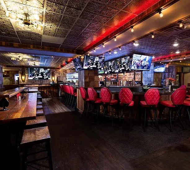 Warm, empty sports bar with ornate ceiling and hockey on TVs.