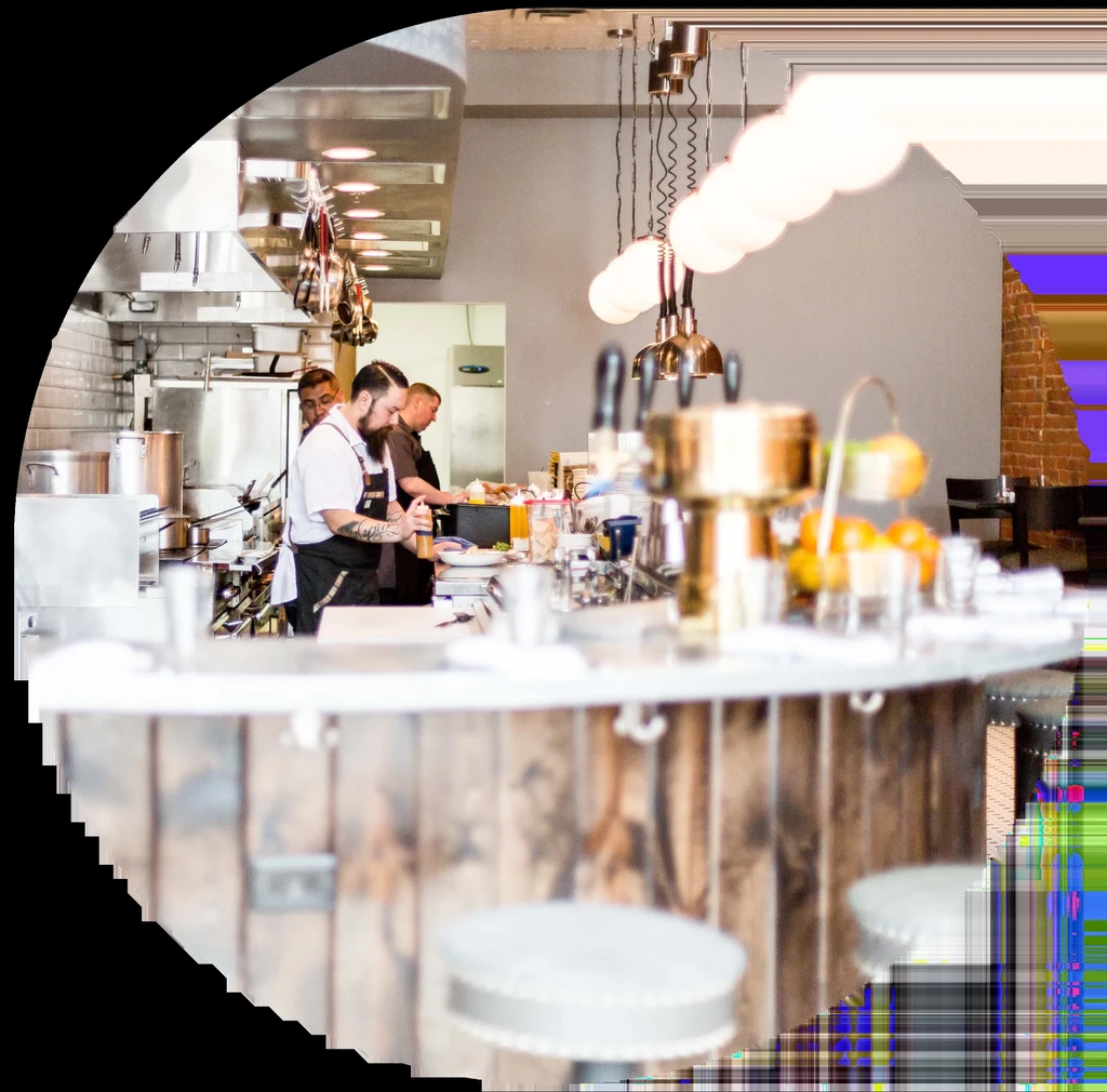 Chefs working in a restaurant's open kitchen and bar.