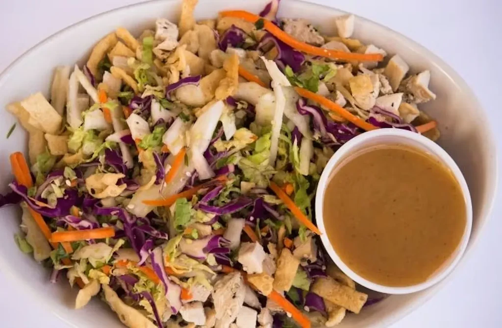 Asian chicken salad with shredded vegetables, chicken, wontons, and dressing.
