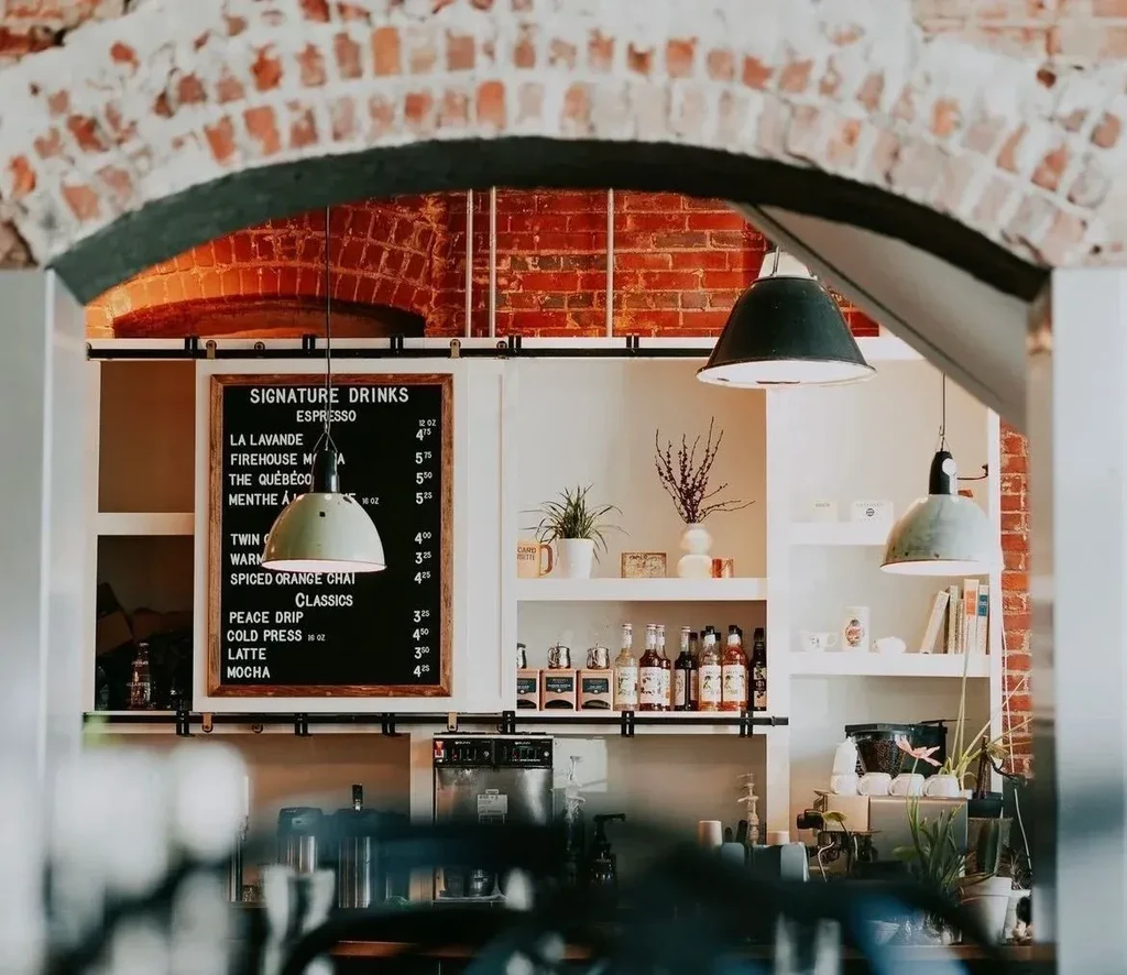 A chalkboard menu for signature drinks inside a brick cafe.