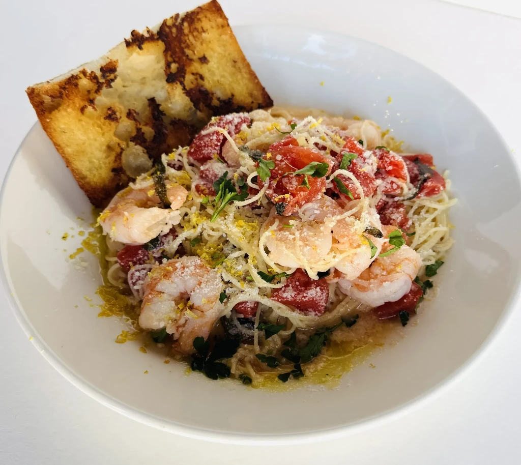 Spaghetti with shrimp, tomatoes, herbs, cheese, lemon zest, and toasted bread.