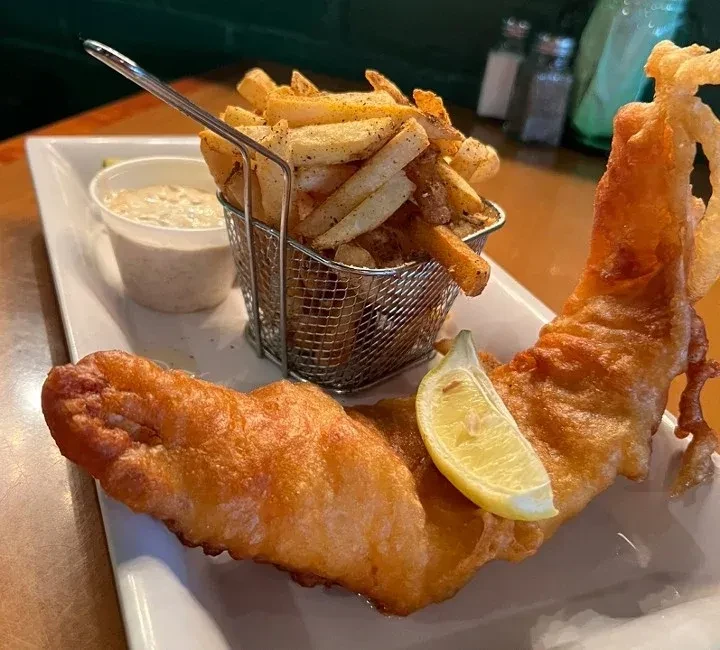 Battered fish and seasoned french fries with lemon and tartar sauce.