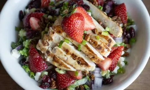 Grilled chicken salad with strawberries, pecans, feta, and cranberries.