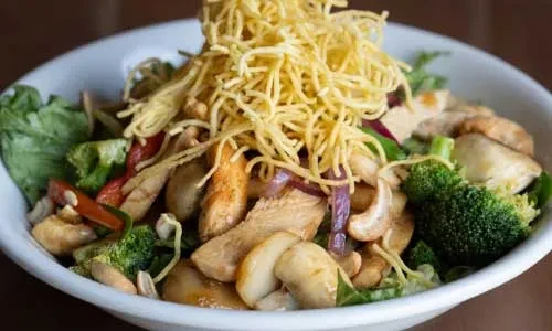 Close-up: Chicken, broccoli, cashews, and crispy fried noodles.