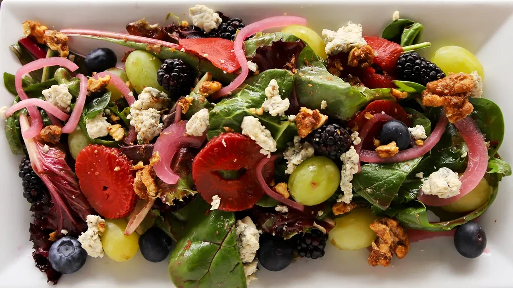 Fresh colorful salad with berries, blue cheese, nuts, and glaze.