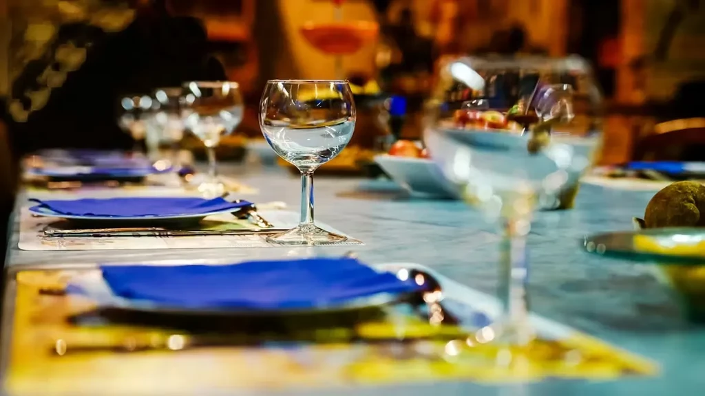 Close-up of a restaurant table with a water glass and warm lighting.