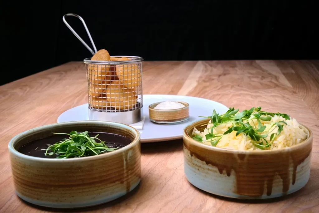 Ceramic bowls of soup and rice, plus fried items with dip.