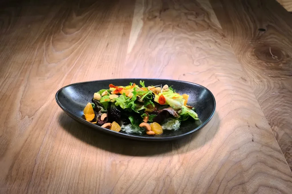 Gourmet salad with fresh greens, candied fruit, nuts, and creamy dressing.