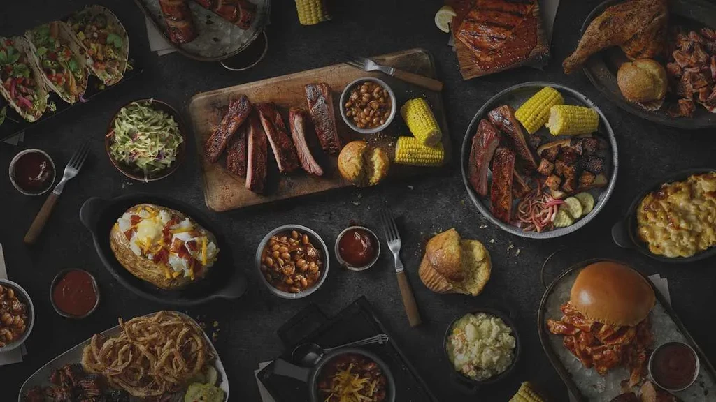 Large overhead spread of barbecue ribs, chicken, sides, and comfort food.