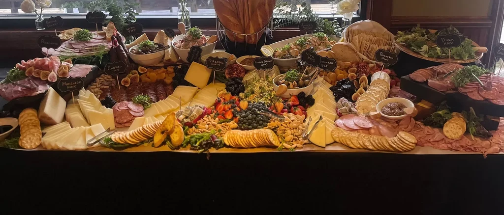 A lavish charcuterie and grazing board with cheeses, meats, and fruits.