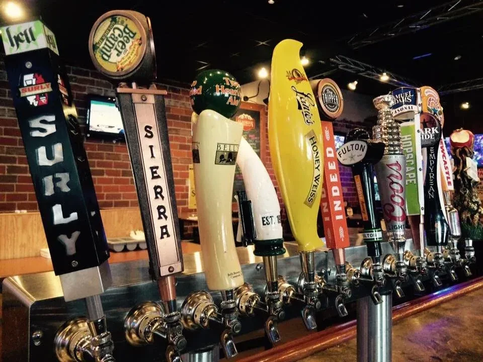 Close-up of many diverse beer tap handles at a restaurant bar.