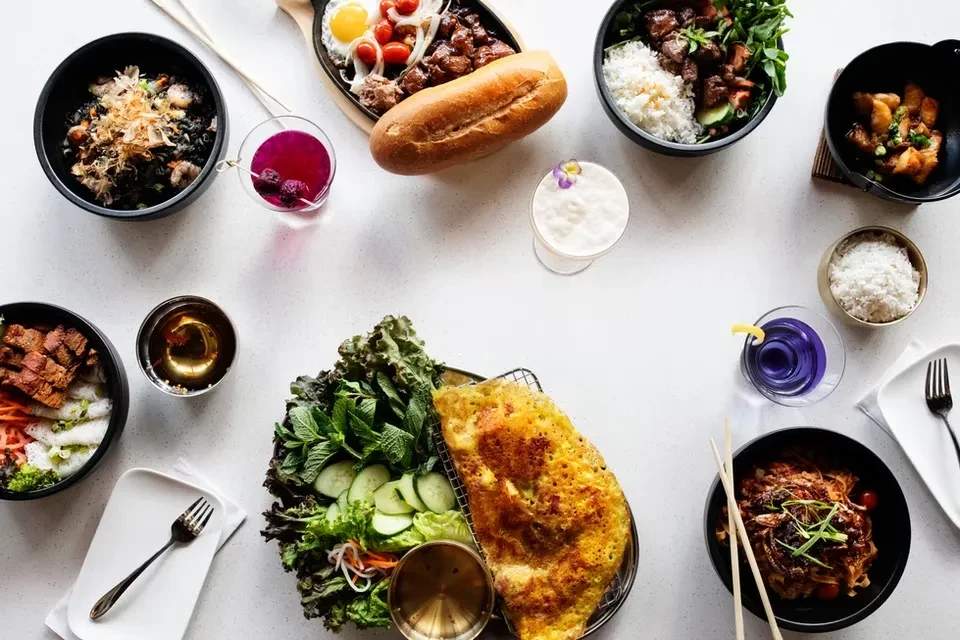 Overhead view of a diverse Asian food and drink spread.