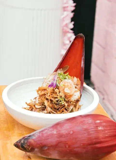 Shrimp salad served in a banana blossom sheath; whole blossom in foreground.