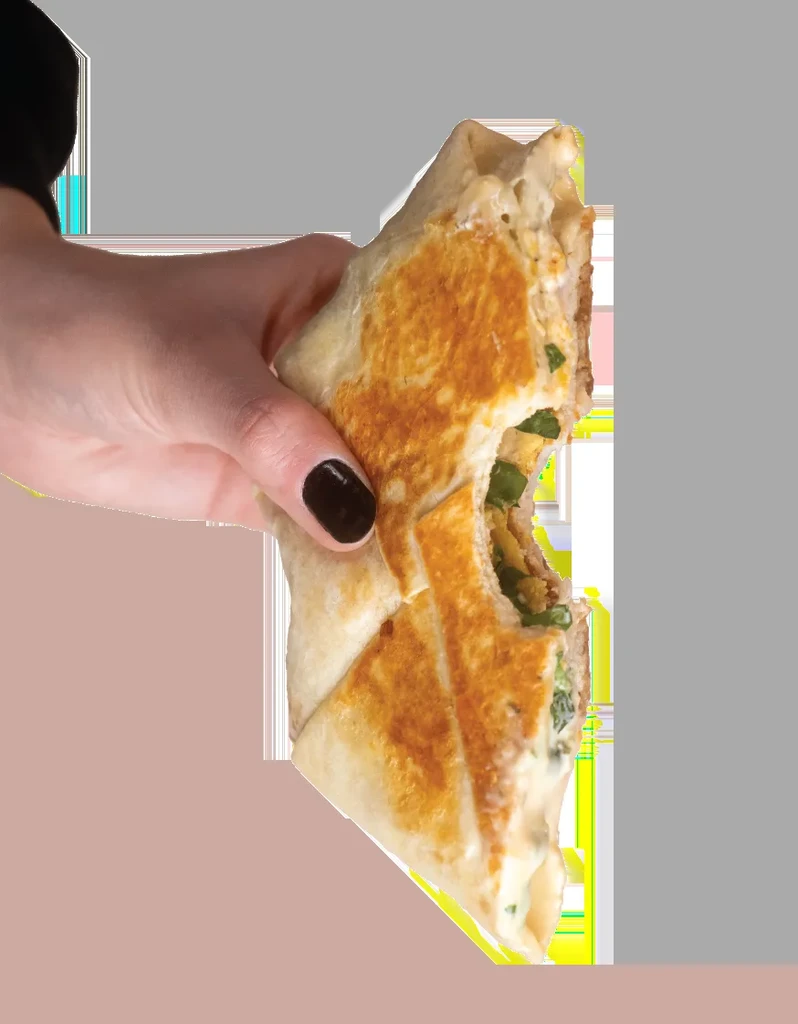 Hand holds a bitten, triangular quesadilla with cheesy, green filling.